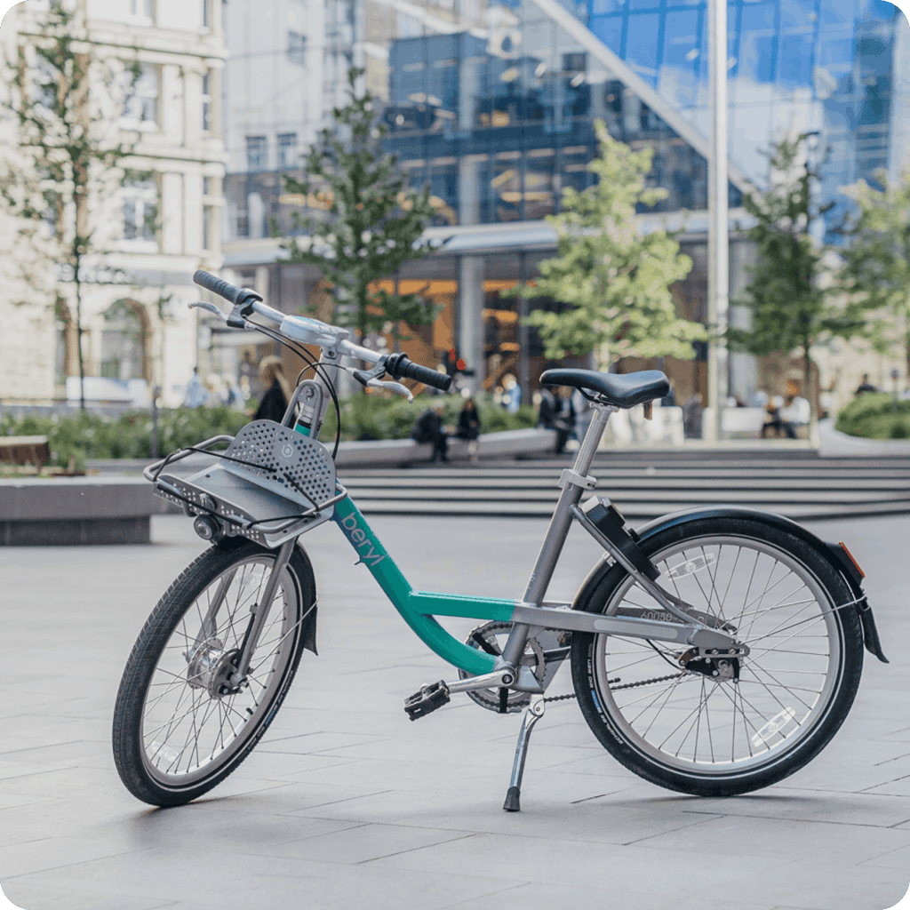 A Beryl bike standing against a city landscape.