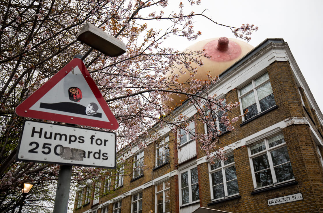 A building with a giant inflatable boob on the roof.