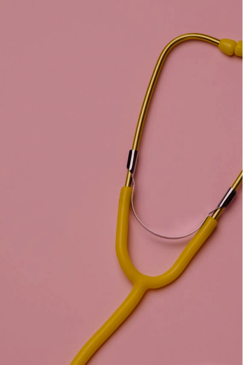 A yellow stethoscope against a pink background.